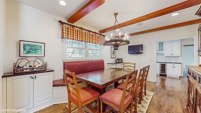 dining room with dark hardwood / wood-style floors, beverage cooler, and beam ceiling