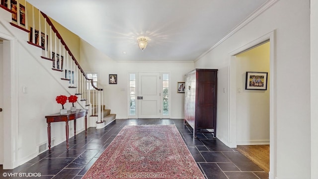 entrance foyer featuring ornamental molding and a healthy amount of sunlight