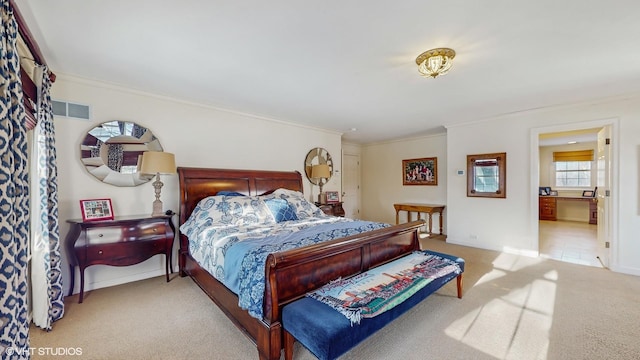 bedroom featuring ornamental molding, light carpet, and ensuite bathroom