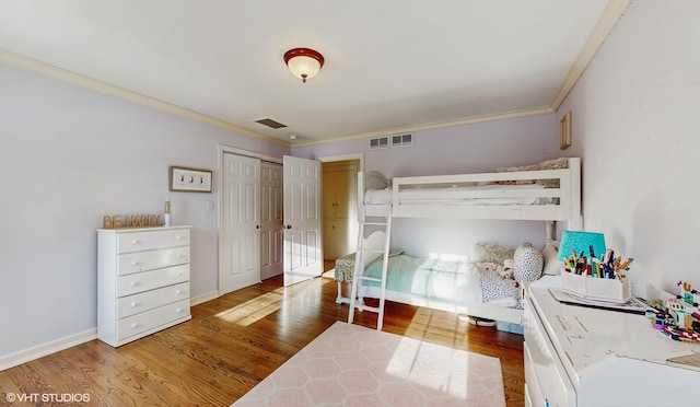 bedroom with ornamental molding, hardwood / wood-style floors, and a closet