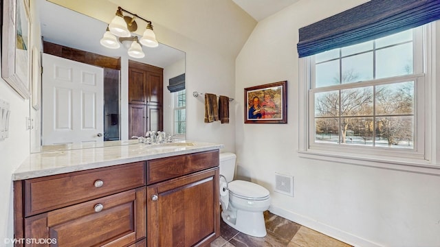 bathroom featuring vanity, a wealth of natural light, tile patterned floors, and toilet