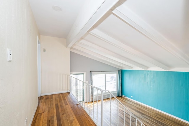 additional living space with wood-type flooring and vaulted ceiling with beams