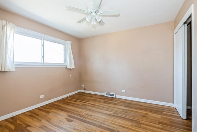 unfurnished bedroom featuring wood-type flooring, ceiling fan, and a closet