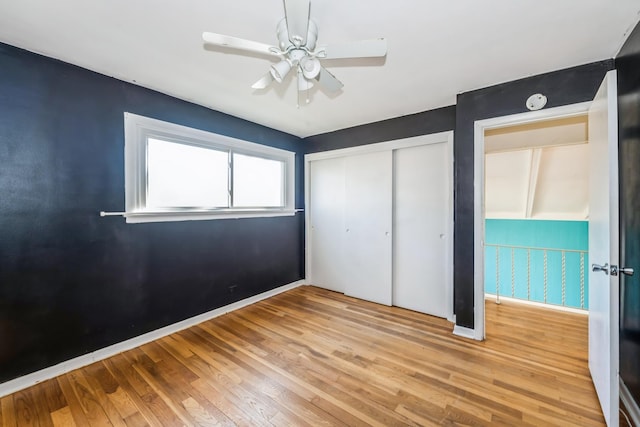 unfurnished bedroom featuring ceiling fan, a closet, and light hardwood / wood-style flooring