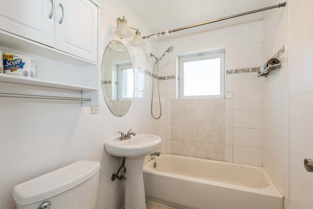 bathroom featuring tiled shower / bath and toilet