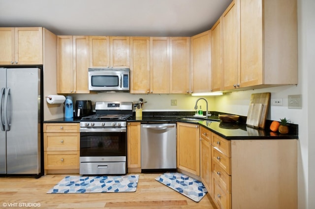 kitchen featuring stainless steel appliances, sink, light hardwood / wood-style flooring, and light brown cabinets