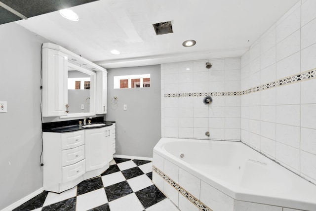 bathroom with tiled shower / bath combo and vanity