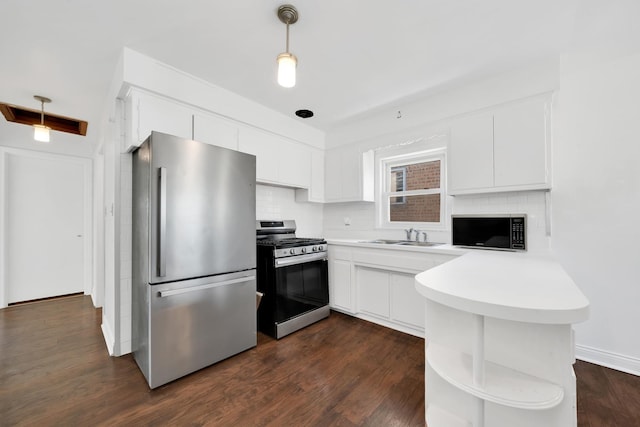 kitchen featuring white cabinetry, stainless steel appliances, decorative light fixtures, and kitchen peninsula