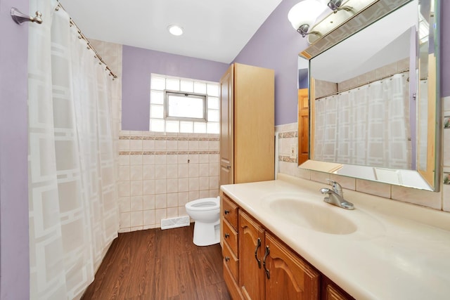 bathroom featuring tile walls, hardwood / wood-style floors, vanity, and toilet