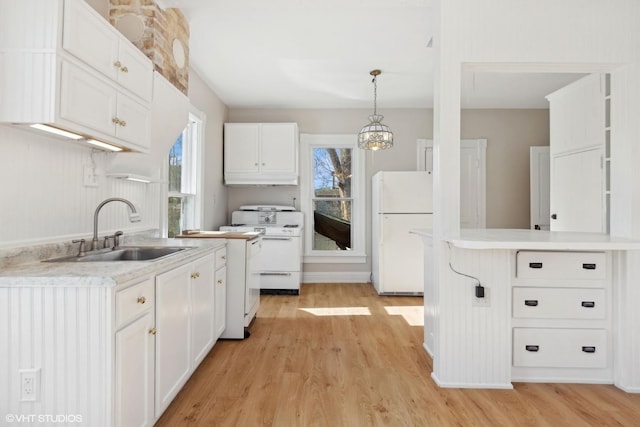 kitchen with sink, plenty of natural light, pendant lighting, white appliances, and white cabinets