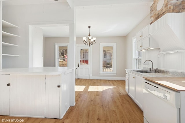 kitchen featuring sink, white cabinetry, hanging light fixtures, light hardwood / wood-style flooring, and white dishwasher