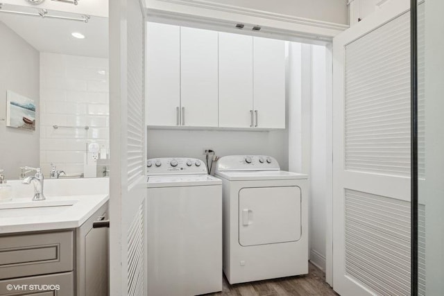 washroom with cabinets, sink, dark hardwood / wood-style flooring, and washing machine and dryer