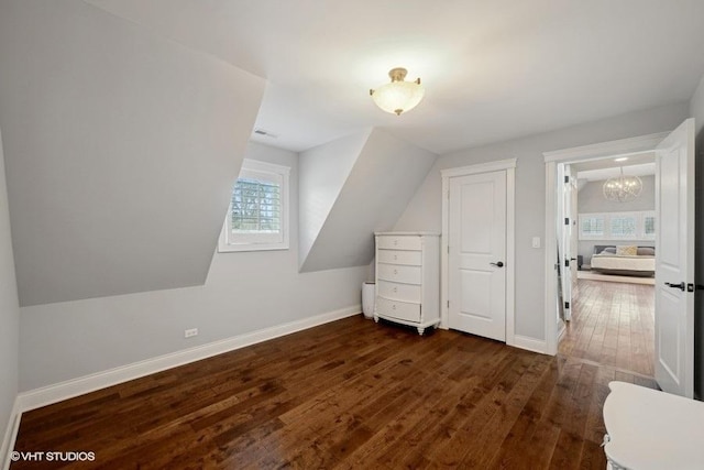 additional living space featuring lofted ceiling and dark hardwood / wood-style flooring