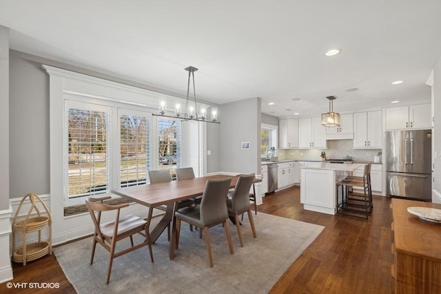 dining area featuring dark wood-type flooring and a notable chandelier