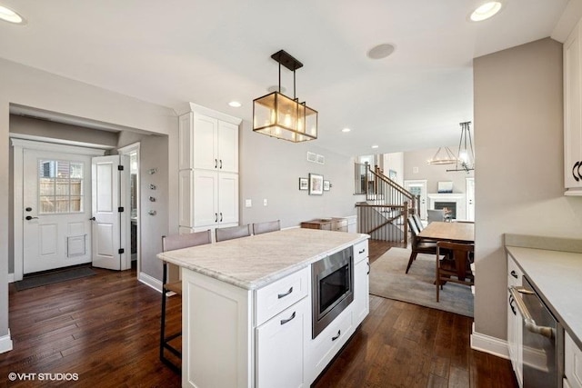 kitchen featuring white cabinetry, decorative light fixtures, dark hardwood / wood-style floors, and appliances with stainless steel finishes