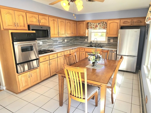 kitchen featuring tasteful backsplash, appliances with stainless steel finishes, sink, and light tile patterned floors