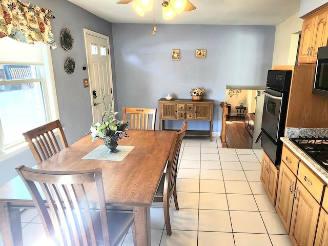 dining space with light tile patterned floors and ceiling fan