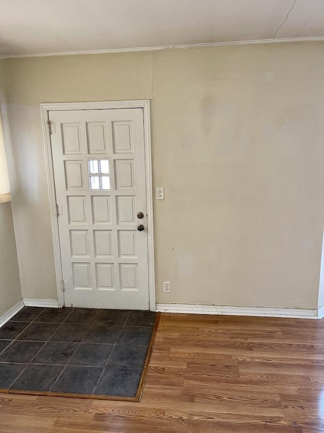 foyer entrance with dark wood-type flooring and ornamental molding