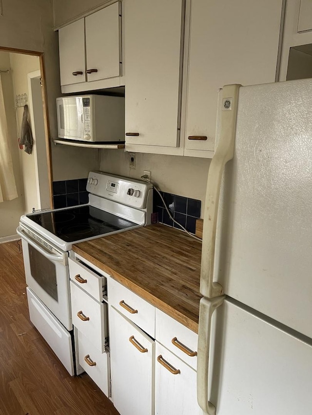 kitchen featuring white appliances, dark hardwood / wood-style floors, butcher block counters, and white cabinets