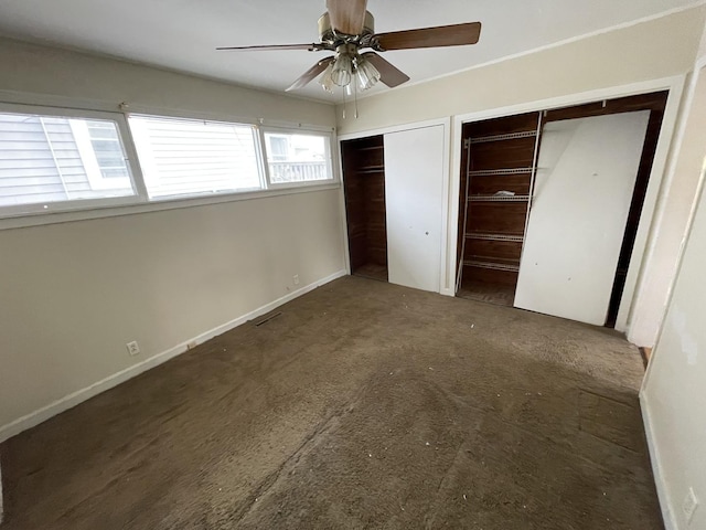 unfurnished bedroom featuring multiple closets and ceiling fan