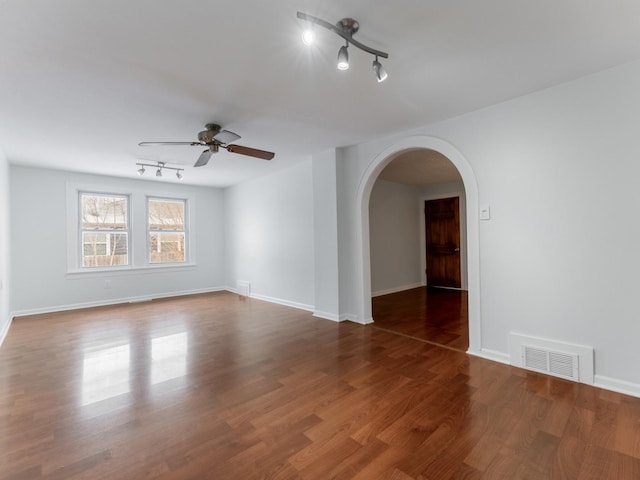 empty room featuring dark wood-type flooring and ceiling fan