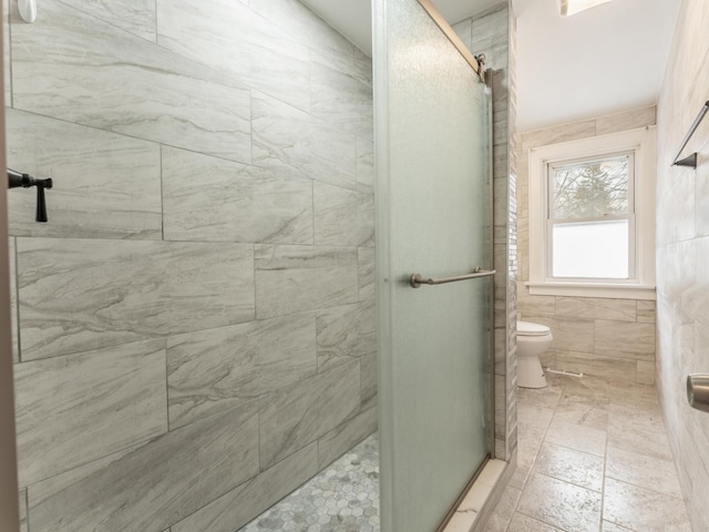 bathroom with tile walls, an enclosed shower, and toilet