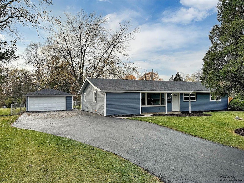 ranch-style house featuring an outbuilding, a garage, and a front yard