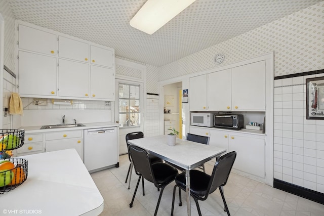 kitchen featuring white appliances, sink, tile walls, and white cabinets