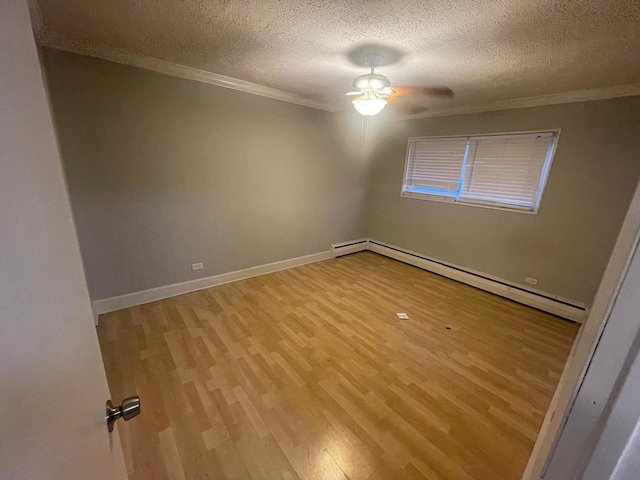 empty room with ornamental molding, light hardwood / wood-style floors, a textured ceiling, and baseboard heating