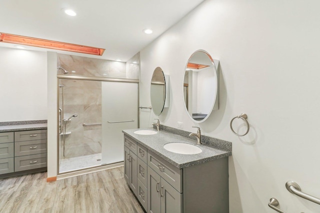 bathroom with vanity, hardwood / wood-style floors, and a shower with shower door