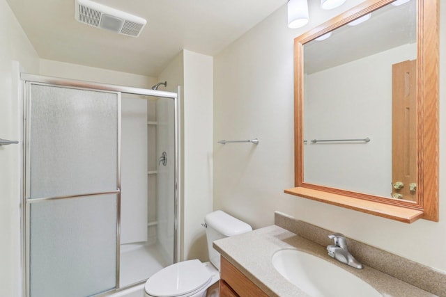 bathroom featuring vanity, an enclosed shower, and toilet