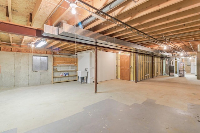 basement featuring sink, heating unit, and gas water heater