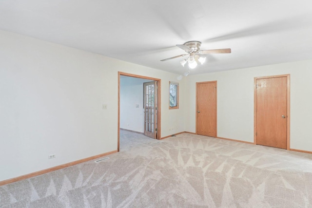 unfurnished room with ceiling fan and light colored carpet