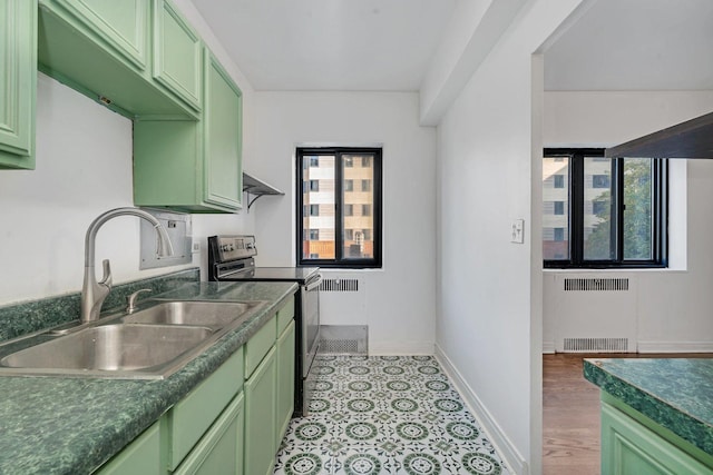 kitchen with sink, stainless steel electric range, radiator, green cabinets, and plenty of natural light