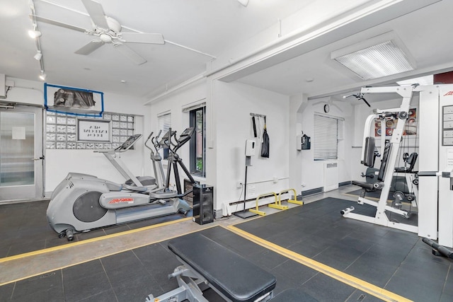 exercise room featuring a baseboard heating unit, track lighting, radiator heating unit, and ceiling fan