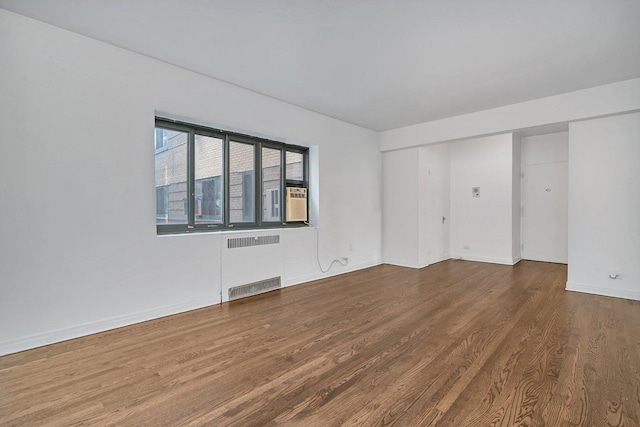 spare room featuring radiator and hardwood / wood-style floors