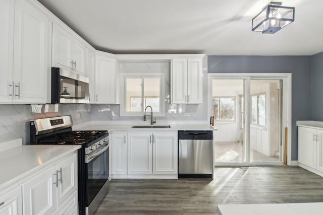 kitchen featuring white cabinetry, appliances with stainless steel finishes, sink, and a wealth of natural light