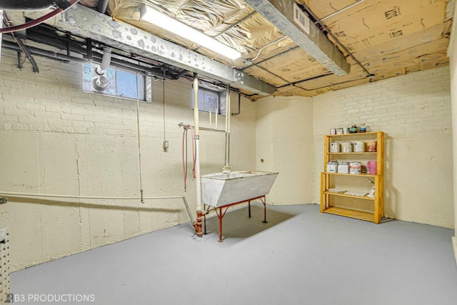 basement featuring brick wall and sink