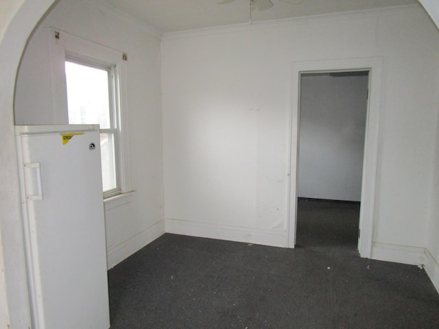 unfurnished room with ceiling fan and ornamental molding