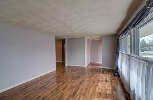 unfurnished room with baseboards and wood finished floors