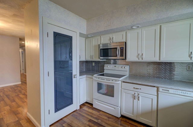 kitchen featuring dark wood-type flooring, light countertops, white appliances, and white cabinetry