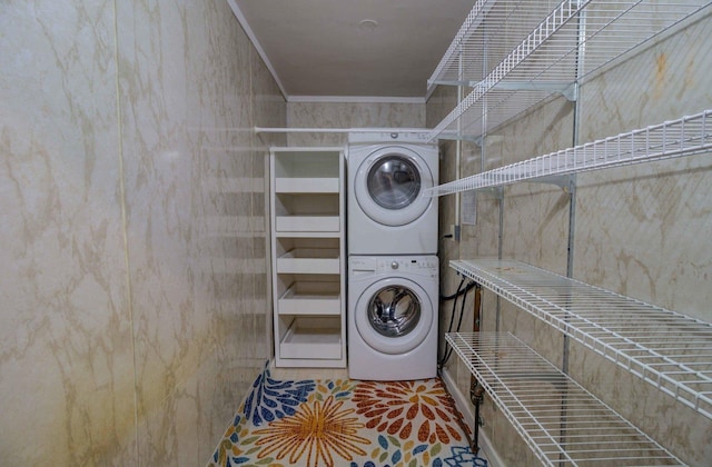 laundry area featuring laundry area, stacked washer and dryer, and crown molding