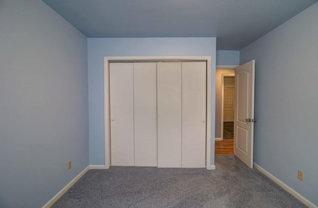 unfurnished bedroom featuring carpet, baseboards, and a closet