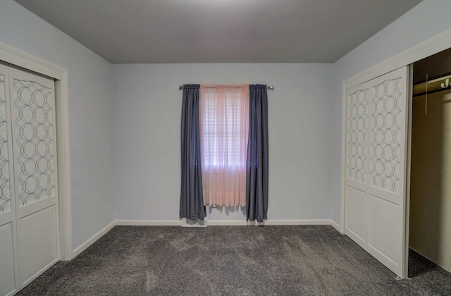 unfurnished bedroom with carpet floors and baseboards