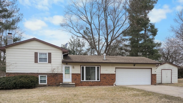 split level home with a garage, brick siding, concrete driveway, a chimney, and a front yard