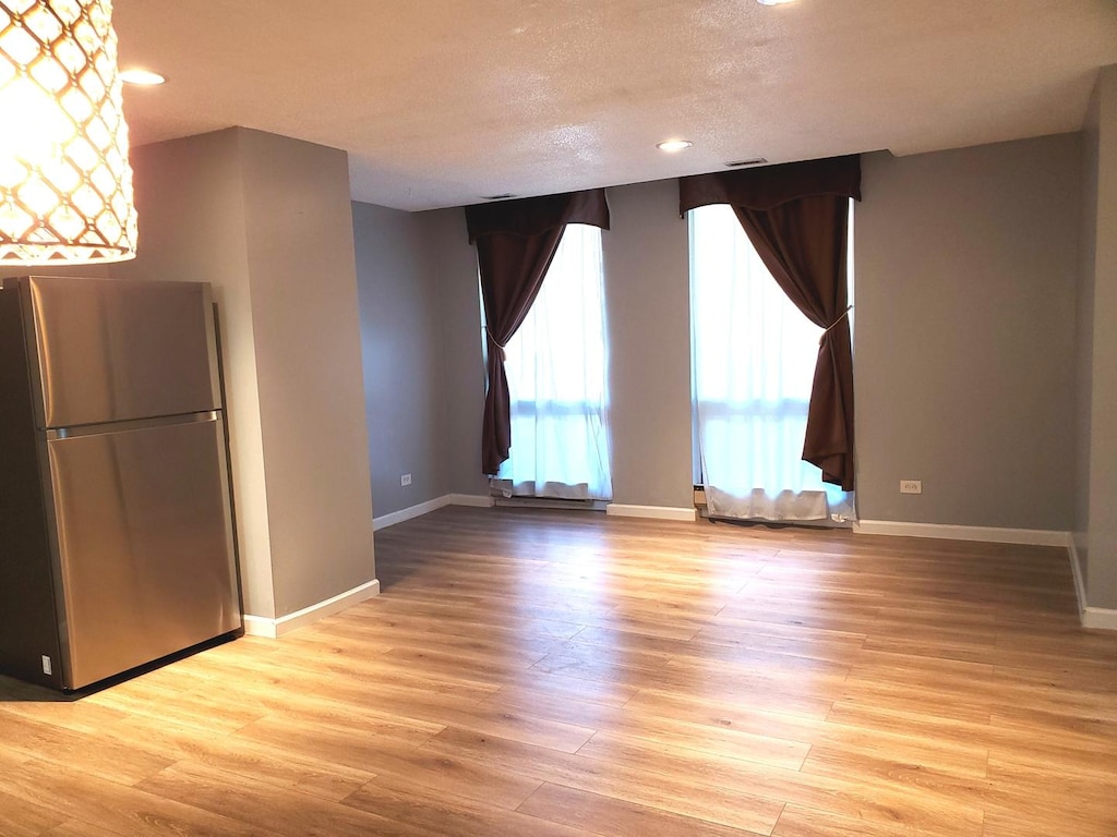 interior space featuring light hardwood / wood-style flooring and a textured ceiling