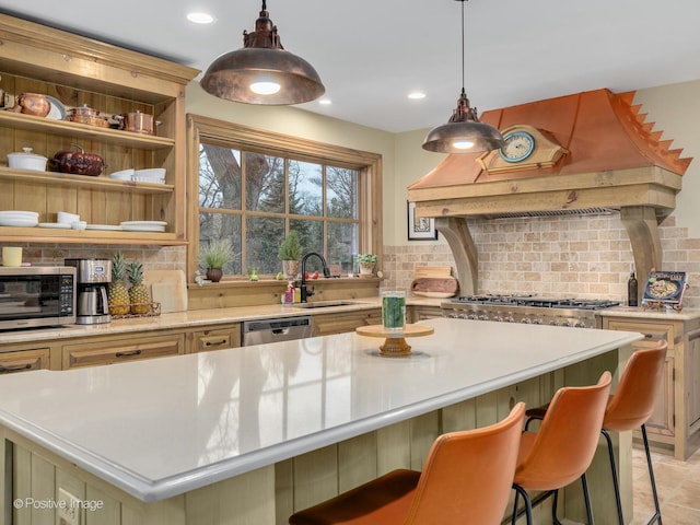 kitchen with sink, hanging light fixtures, a center island, custom range hood, and a kitchen bar