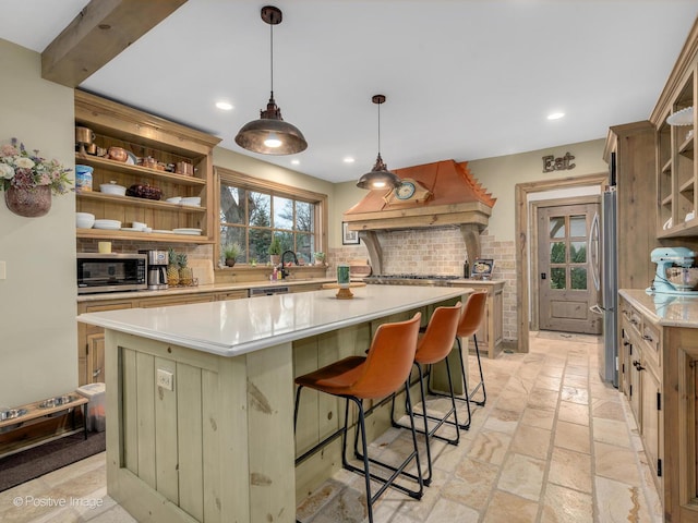 kitchen with premium range hood, stainless steel appliances, tasteful backsplash, a kitchen island, and decorative light fixtures