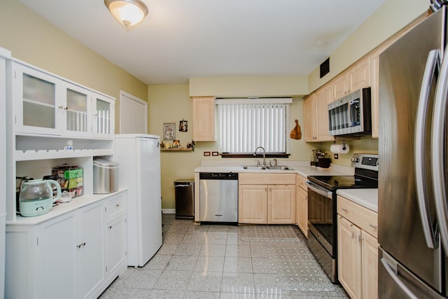 kitchen featuring light brown cabinetry, sink, and appliances with stainless steel finishes