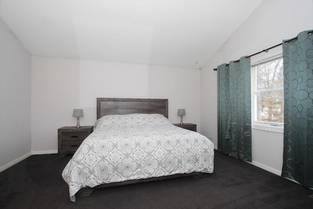 bedroom with vaulted ceiling and dark carpet